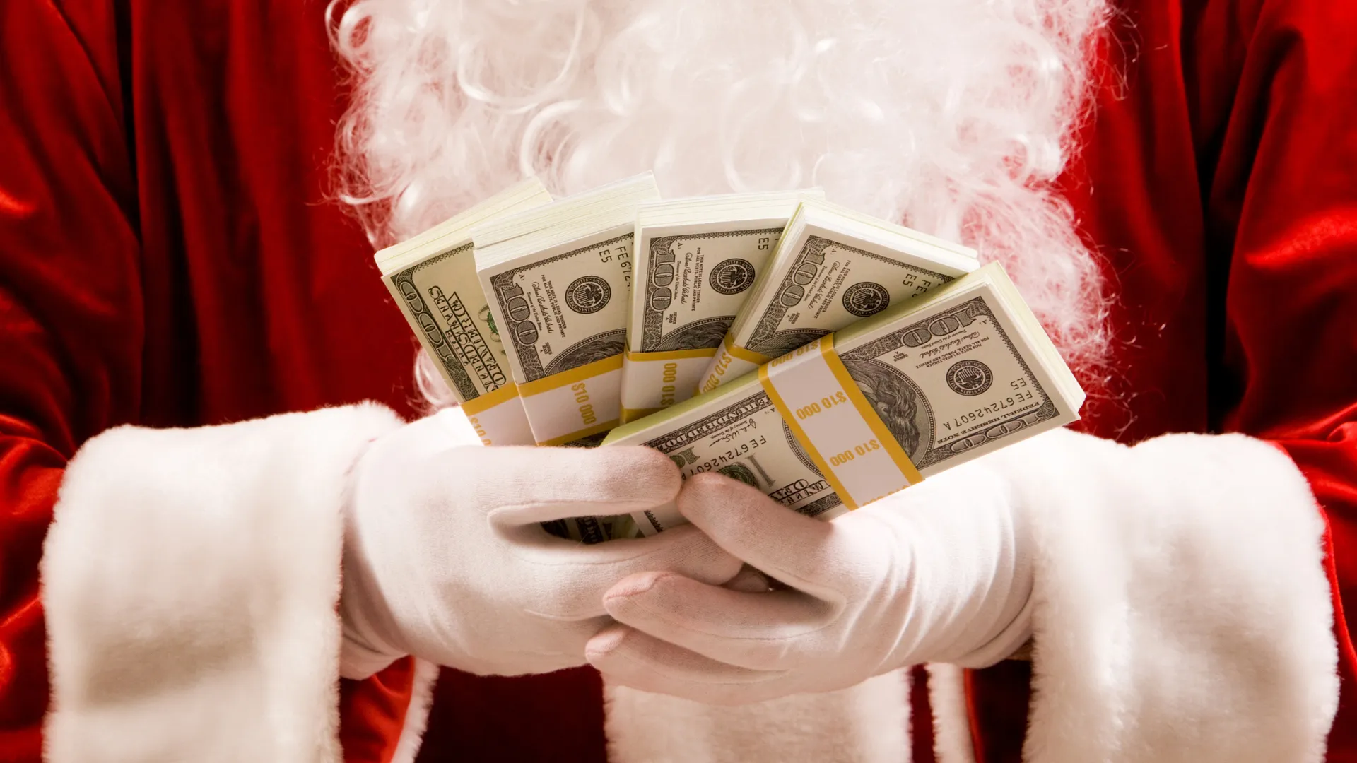 Close-up of Santas hands with stacks of dollar banknotes.