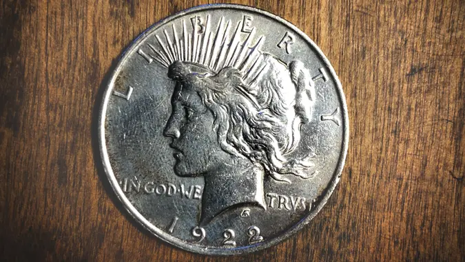 Peace dollar from 1922 with a wooden background.