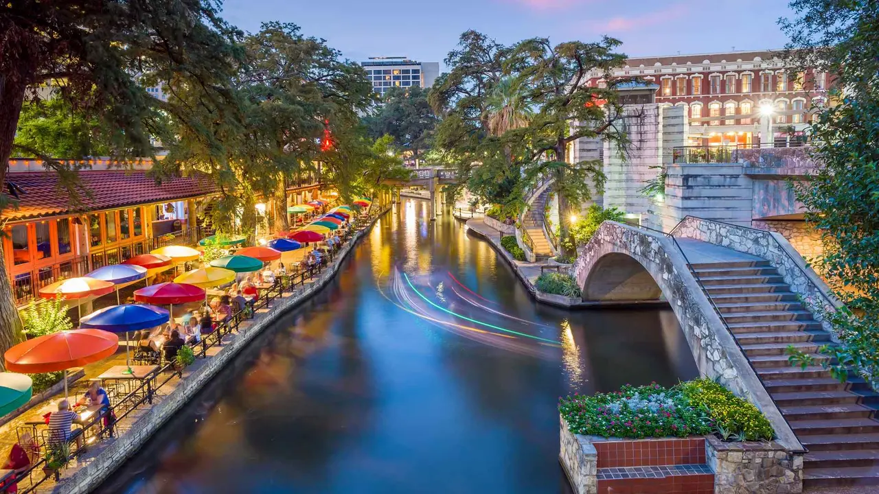 River walk in San Antonio city downtown skyline cityscape of Texas USA at sunset.