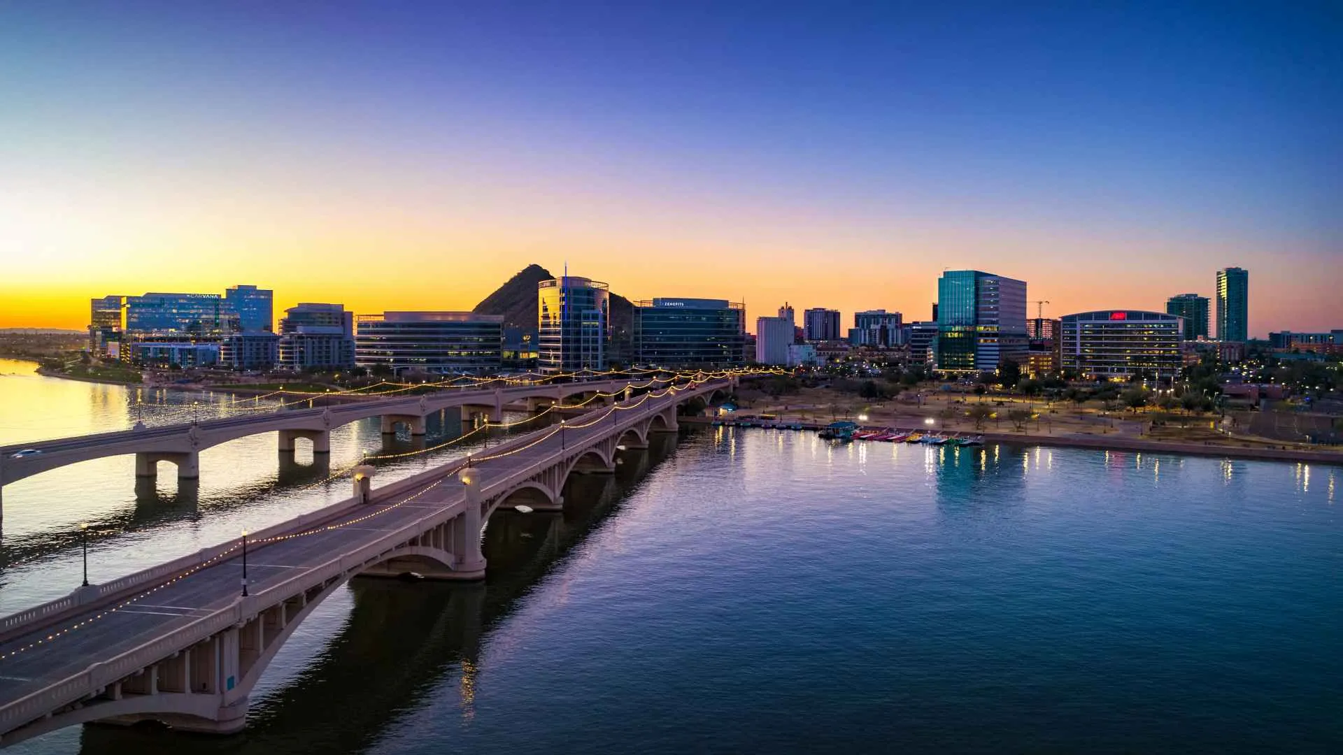 Downtown Tempe, Arizona at dawn with bridges and Tempe Town Lake in the foreground.