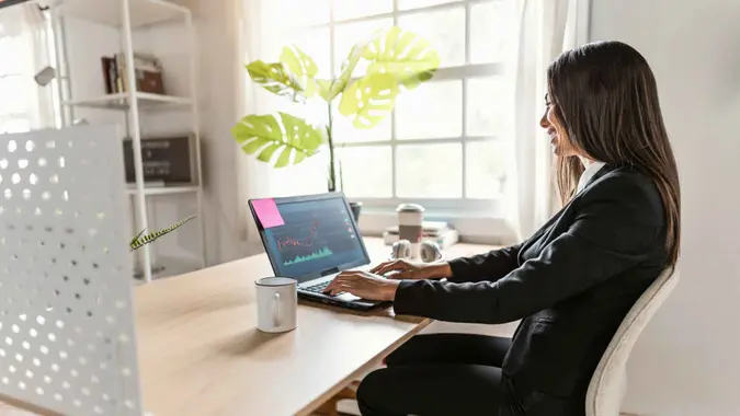 Woman working on her cryptocurrency markets at home.