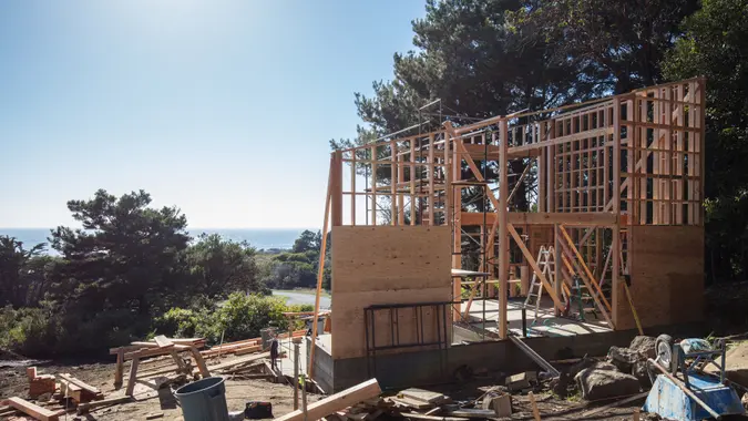 House construction framing in California by pacific ocean on sunny day.