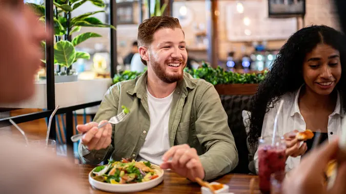 Young man eating with his friends on a restaurant stock photo