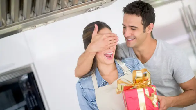 Man surprising woman with a present stock photo