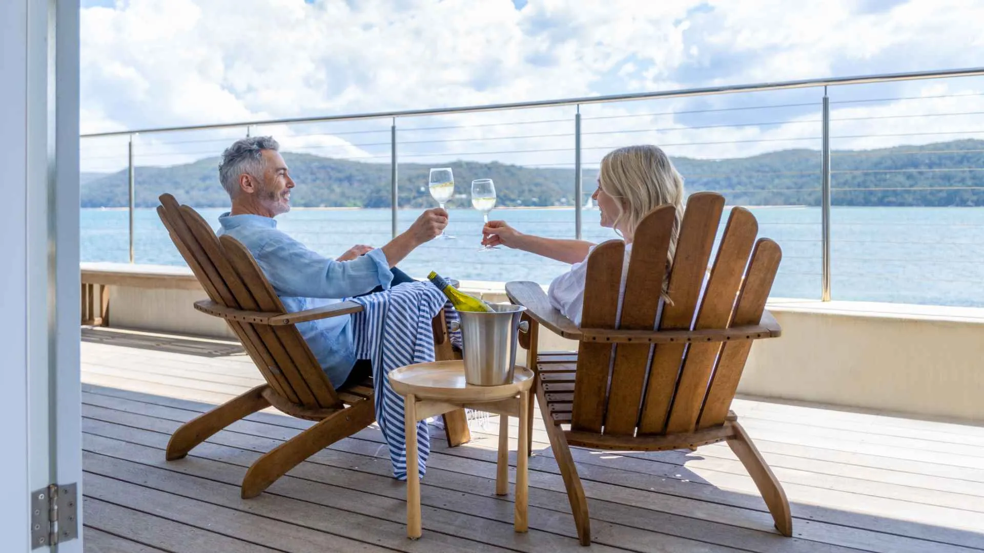 Mature couple drinking wine out on the deck.