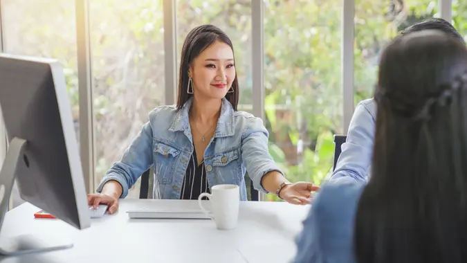 Large group of Portrait Young woman submit resume to employer to review job application. The concept presents the ability for the company to agree with the position of the job in financial real estate business company stock photo
