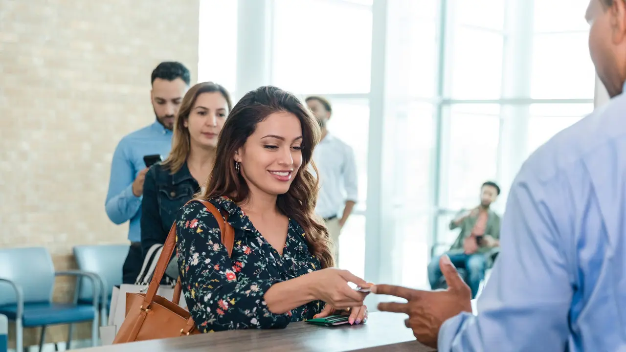 A woman at a bank uses the banks products and services to build her wealth