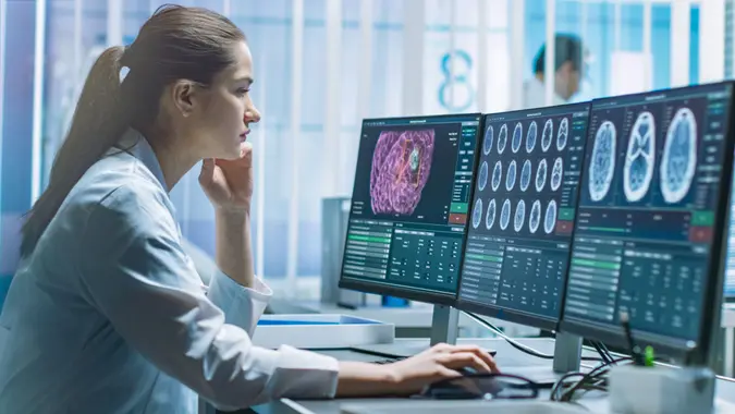 Female Medical Research Scientist Working with Brain Scans on Her Personal Computer.