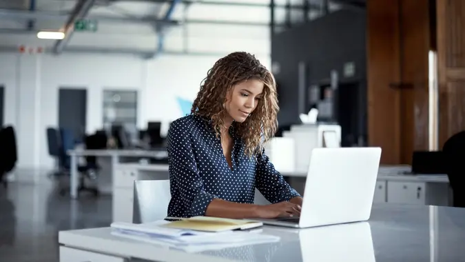 A woman sits at her desk at work.