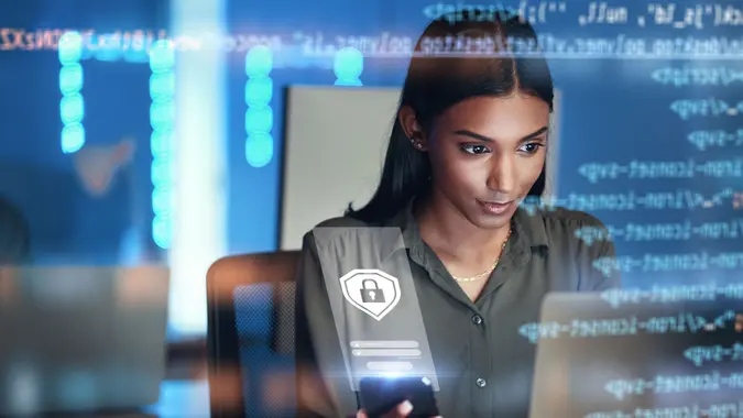 An IT or cybersecurity expert works on her computer.