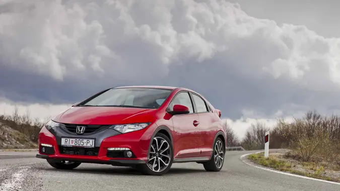 "Ogulin, Croatia - April 7th, 2012: New Honda Civic parked on the road near Bjelolasica mountain with heavy clouds watching over.