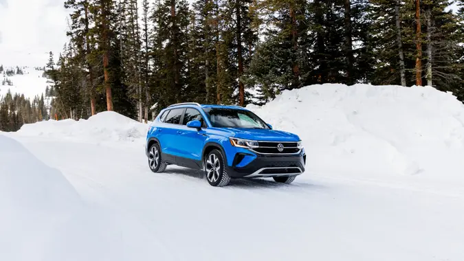 2024 Volkswagen Taos parked in snowy woods for promotional image.