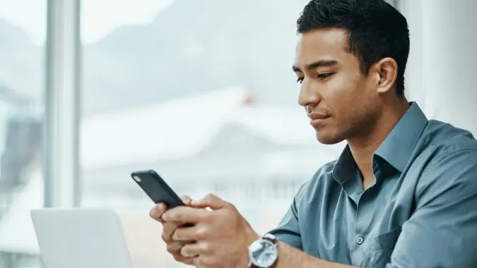A man looks at his phone while working from home.