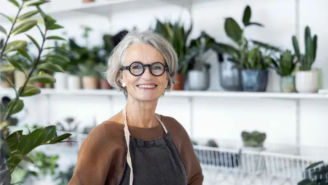 Portrait of senior female florist at small business flower shop.