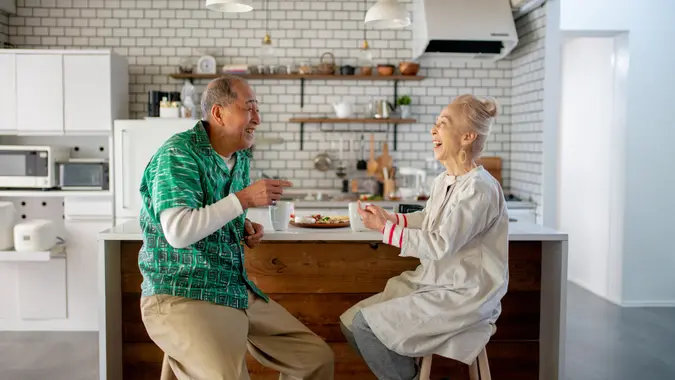 Senior couple relaxing at home in the kitchen together.