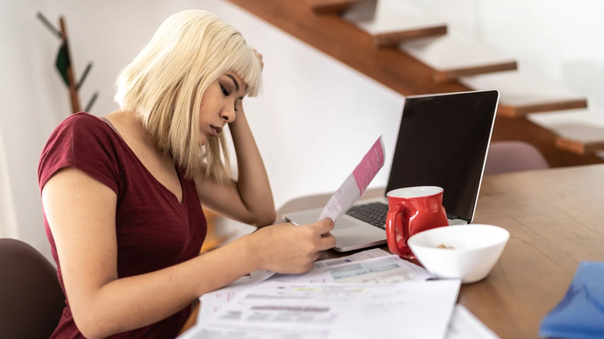 Worried woman looking for financial bills at home.
