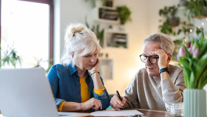 Senior couple sitting at the table discussing home finances.