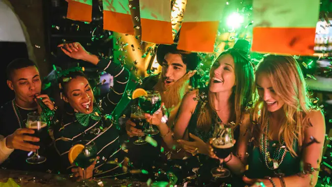 Happy multi-ethnic friends drinking and having fun at Saint Patrick's day night club party.