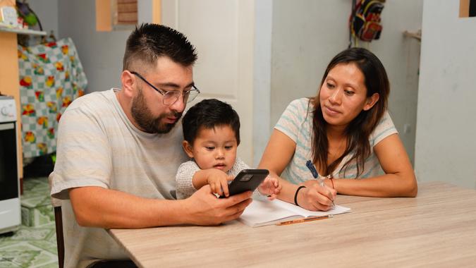 Hispanic couple reviewing and planning their finances Happy young married couple sitting at home calculating household expenses. couple doing their accounts in the living room at home stock photo