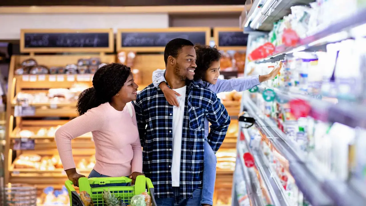 Portrait of happy black family with shopping carts together at grocery store.