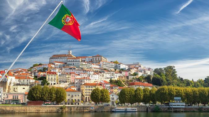 View on the old university city of Coimbra and the medieval capital of Portugal with Portuguese flag, Europe.