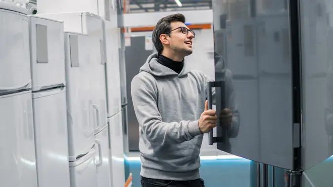 Customer choosing large fridges in domestic appliances section stock photo