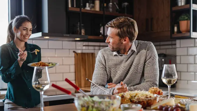 A young man and woman eating homemade meal at home.