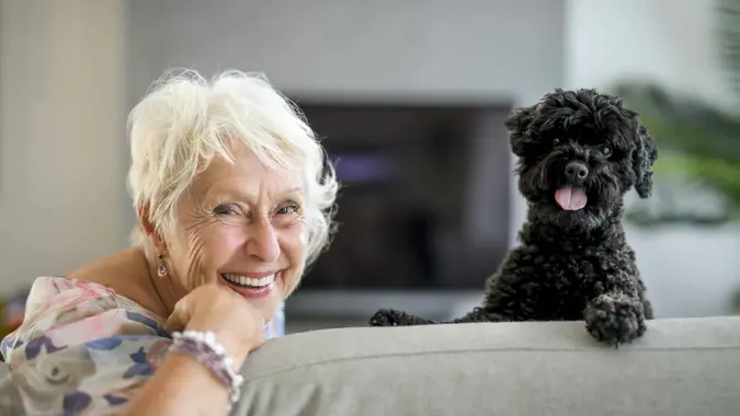 A cute senior woman with poodle on the living room.