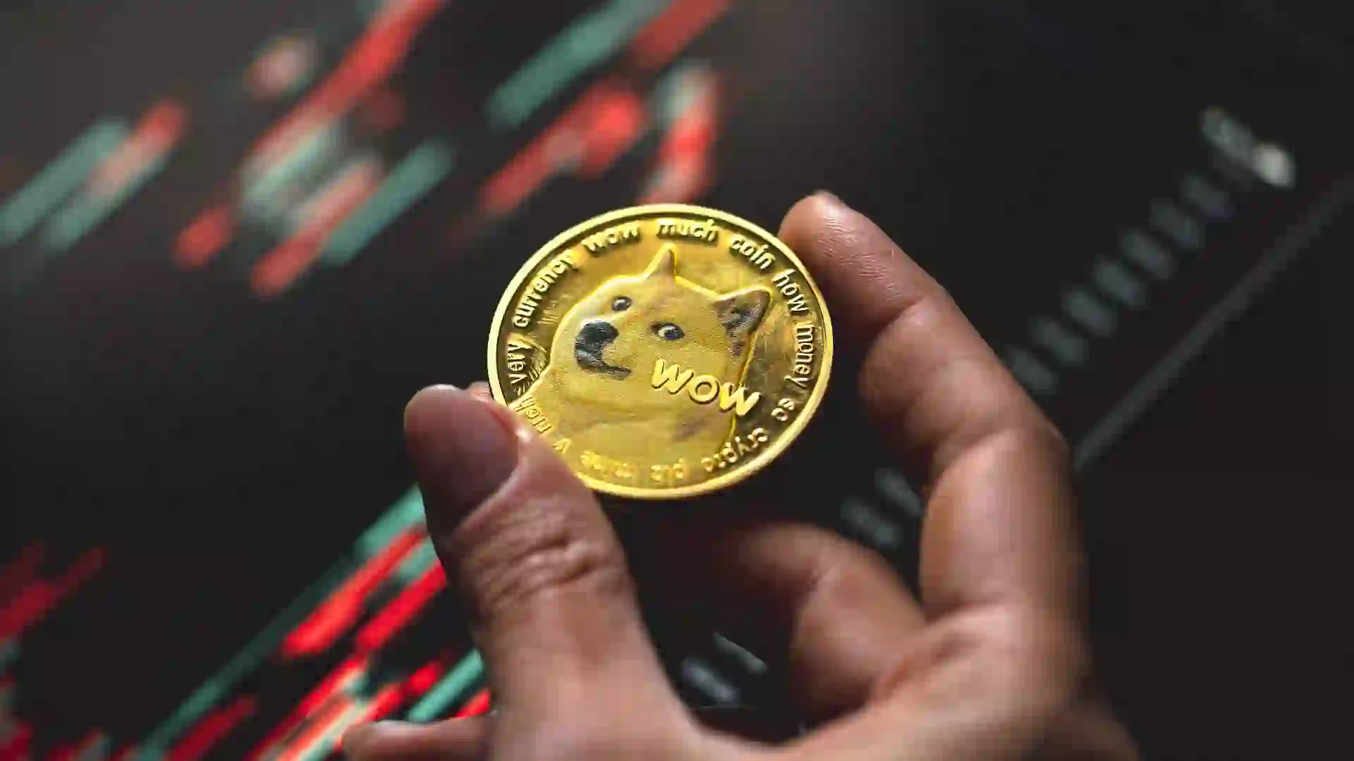 Hand holding a gold Dogecoin coin with candle stick graph chart and digital background stock photo