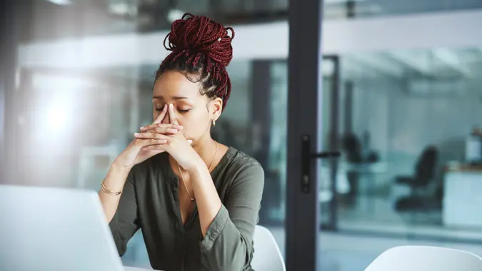 Shot of a young businesswoman looking stressed out while working in an office.