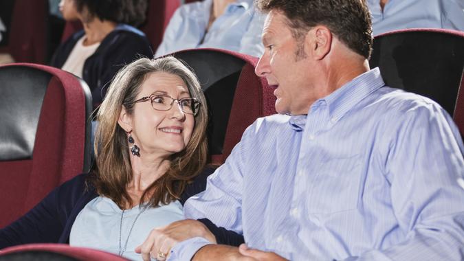 Mature couple in movie theater, multi-ethnic audience stock photo