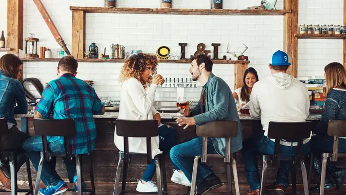 Shot of young people enjoying a drink at a bar.