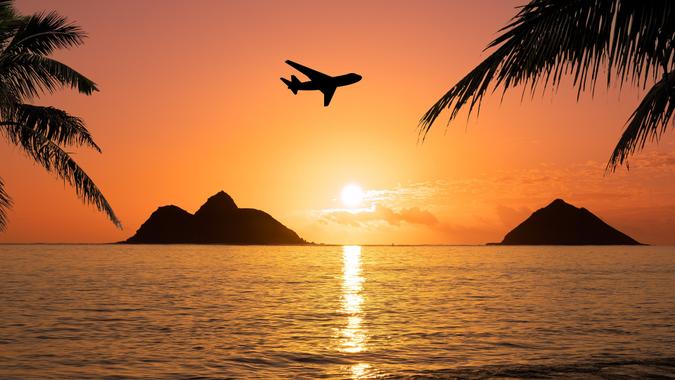 Plane traveling to hawaii with sunset and palm trees stock photo