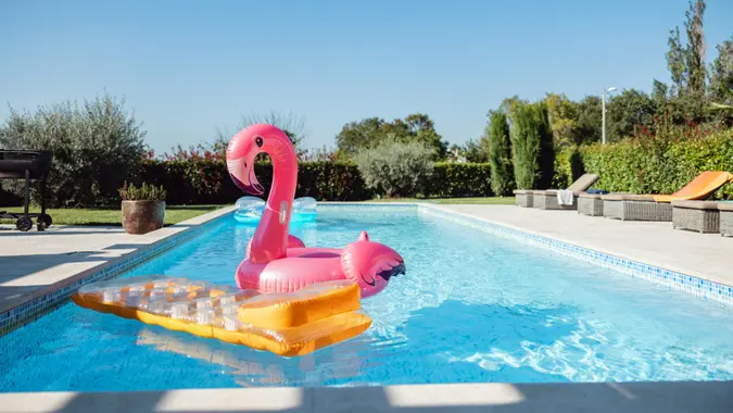 Cute and colourful pool floats floating on the water of the empty pool.