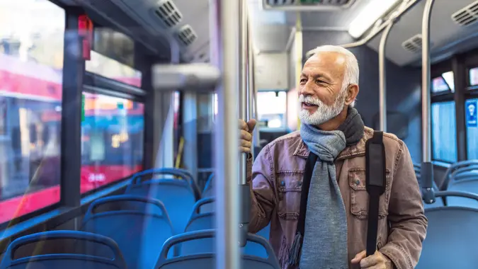 Photo of Mature tired businessman travelling by bus in city during winter day.