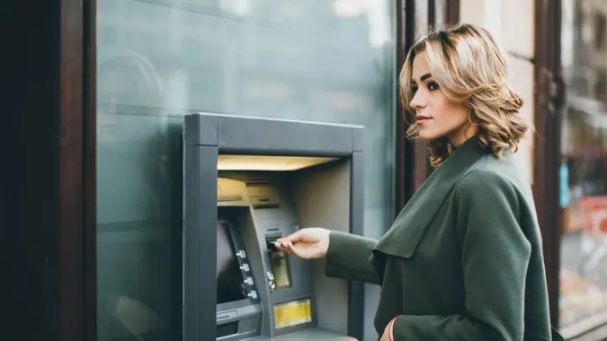 Young woman using a cash machine.
