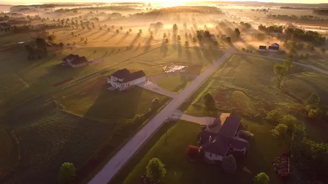Etherial sunrise through misty fog with long shadows and sunbeams.