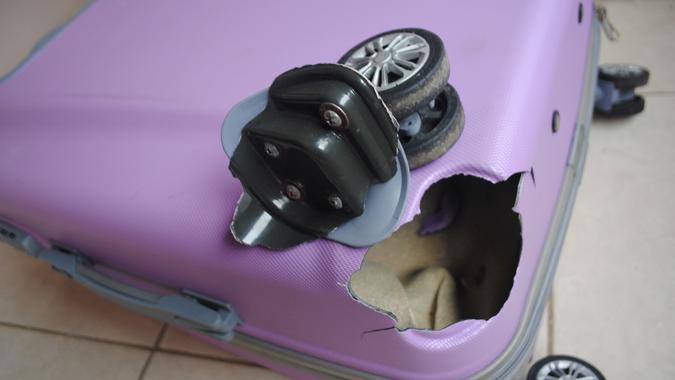 broken wheel cheap luggage_iStock-2006781479 Broken wheel on a luggage bag. stock photo
