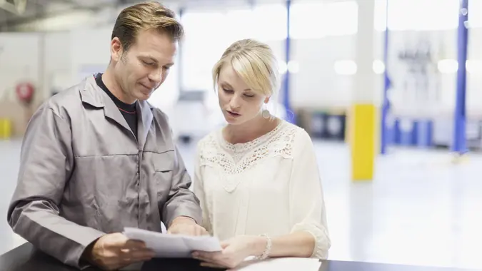 Mechanic talking to customer in garage stock photo