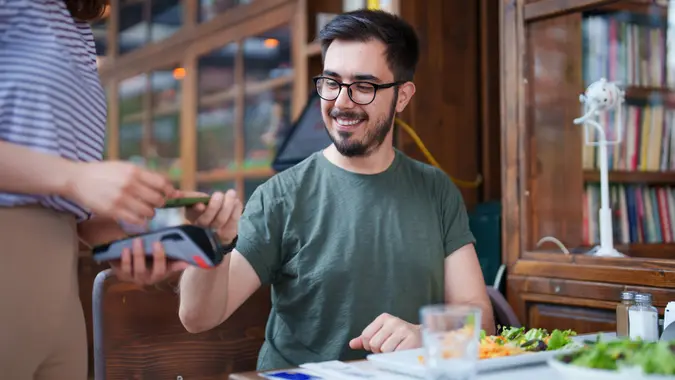 The man paying the restaurant bill with his mobile phone stock photo