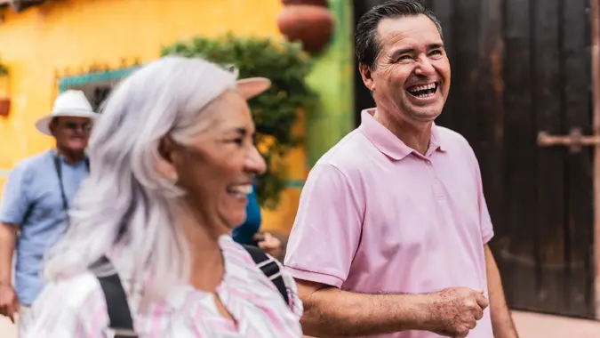 Senior tourist friends talking while walking through tourist town stock photo