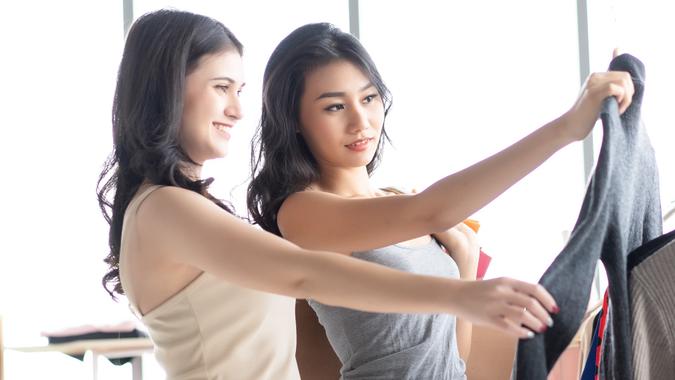 Portrait of two Asian happy girls with paperbags shopping in clothes store stock photo