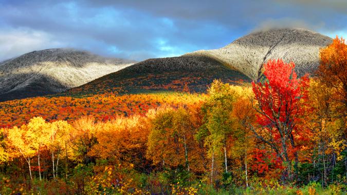 Peak fall foliage and snowcapped mountians in New Hampshire's White Mountains.