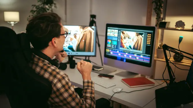 Young casually clothed editor working from home office setup.