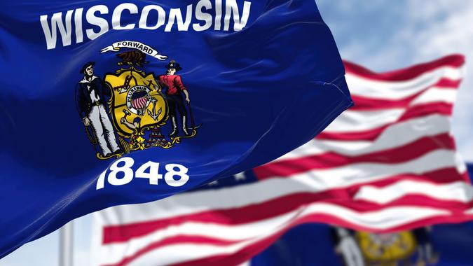 The Wisconsin state flag waving along with the national flag of the US stock photo