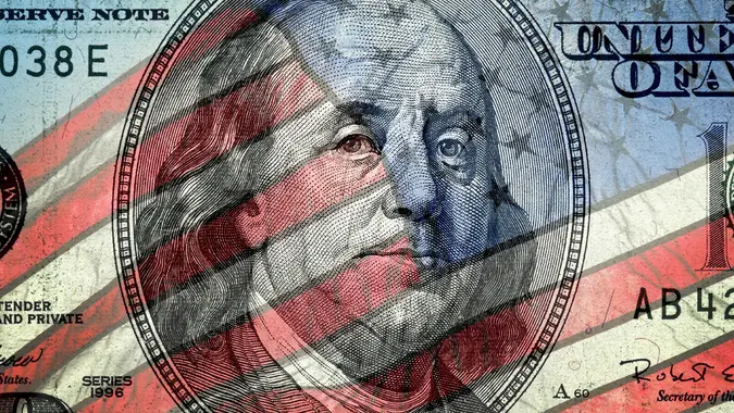 American one hundred dollar bill and American flag stock photo