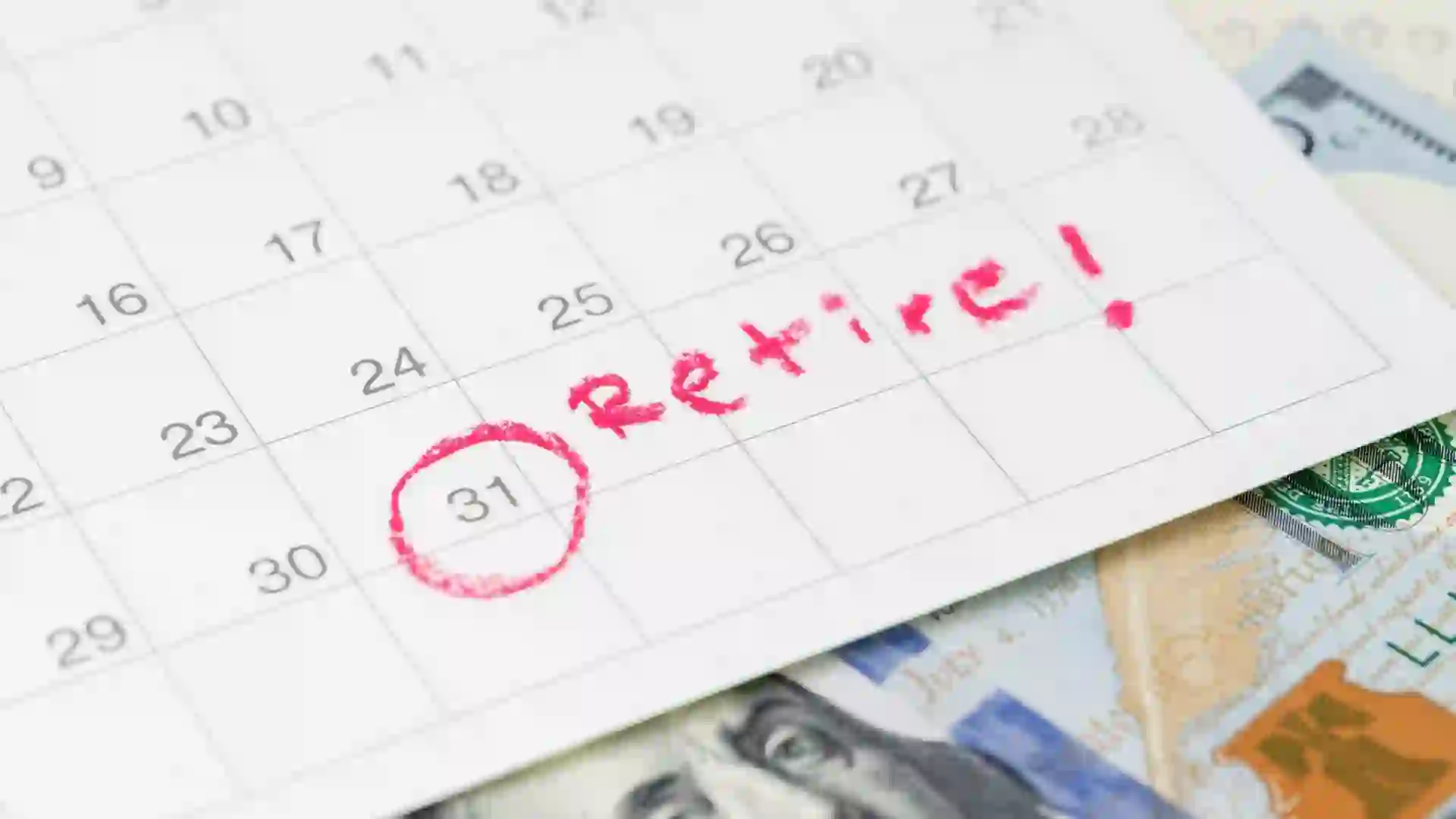 Calendar with 'Retire!' written on the 31st, alongside cash, symbolizing retirement planning.