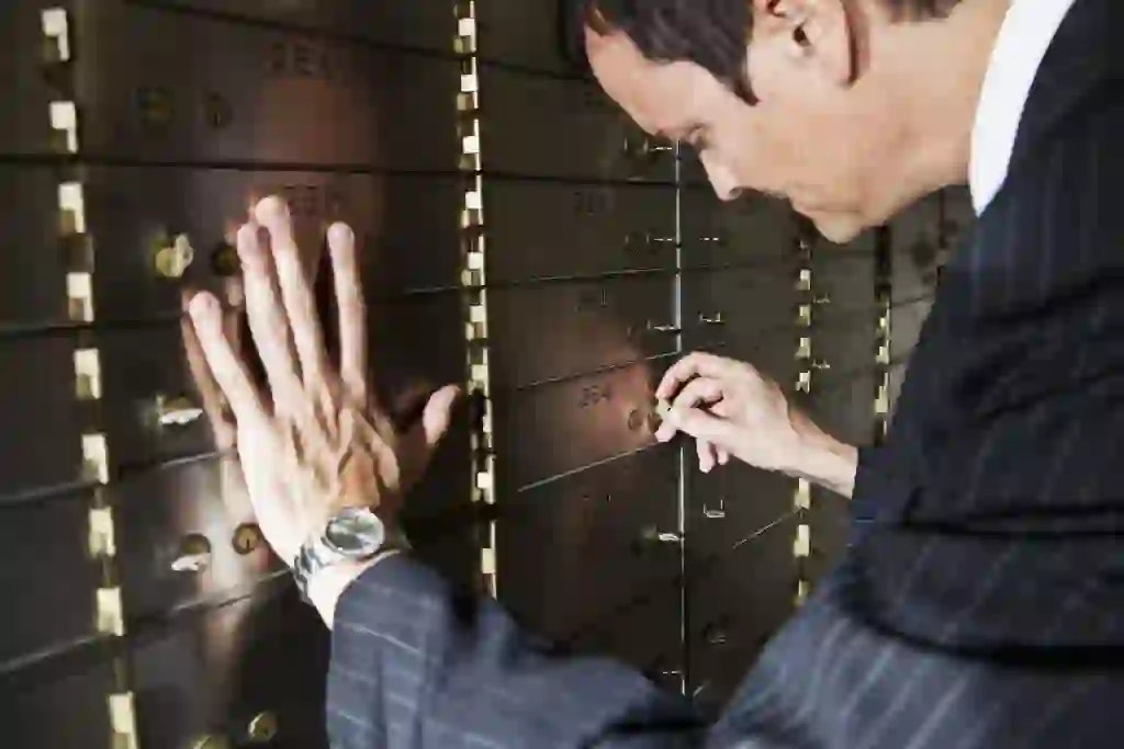 Mature man in business suit opening safety deposit box.