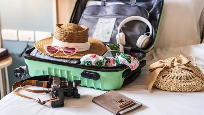 Traveler suitcase and luggage with travel accessories and items preparing for travel.