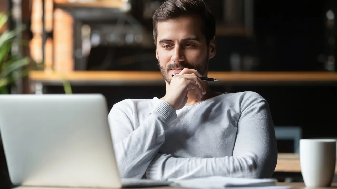 Thoughtful businessman think of online project looking at laptop stock photo